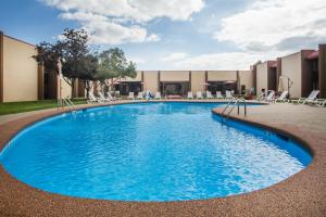 a large swimming pool with chairs and a building at Ramada by Wyndham Statesville in Statesville