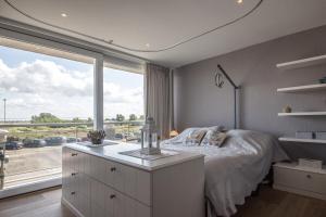 a bedroom with a bed and a large window at Res Helix 1slp kamer app Zeezicht en Parking in Middelkerke