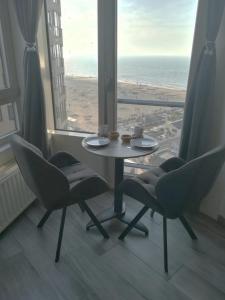 a table and chairs in a room with a view of the beach at WAW vakantie appartement in Westende
