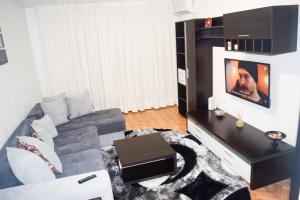 Una sala de estar con un sofá y un televisor. en Sunrise, en Alba Iulia