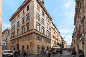 un gran edificio en una calle de la ciudad con gente caminando en iFlat Vatican High-End Apartment en Roma