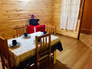une salle à manger avec une table, des chaises et une boîte rouge dans l'établissement O NEGRAÕ, à Puerto Iguazú
