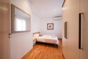 a small bedroom with a bed and a mirror at Apartment Milka with sea view in Tisno