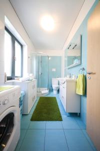 a blue bathroom with a washing machine in it at Apartment Milka with sea view in Tisno +45 photos