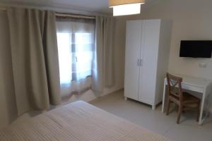 1 dormitorio con cama, escritorio y ventana en B&B Mansarda del Sole, en Nápoles