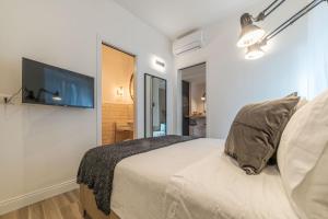 羅馬的住宿－Appia New Cozy Apartment，一间卧室配有一张床和一台平面电视