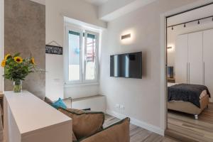 un soggiorno con tavolo e TV a parete di Appia New Cozy Apartment a Roma