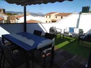 a patio with a blue table and chairs on a roof at Duplex Jalama II in Moraleja