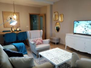 a living room with a couch and chairs and a tv at Duplex Jalama II in Moraleja