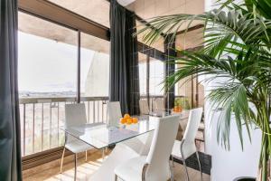 a dining room with a glass table and white chairs at Loft Triangle comedie, Parking free in Montpellier