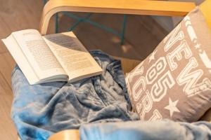 a book sitting on top of a bed with a pillow at La Casa Rosa in Terni