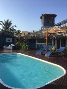 una piscina con sillas y una casa en Cabana Chic Sunrise en Tatajuba