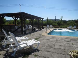 un grupo de sillas blancas sentadas junto a una piscina en Cabañas Club Mediterraneo en Quillón