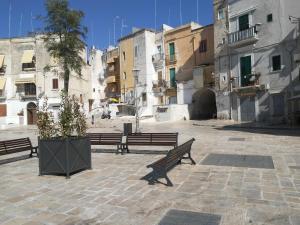 two benches sitting in a courtyard with buildings at Joy's Home in Bari