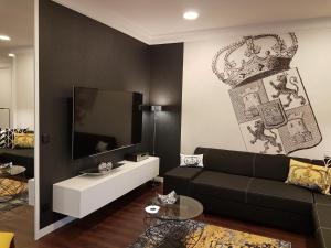 a living room with a black couch and a tv at A&M Apartment Ahorn/Hohenstadt in Hohenstadt