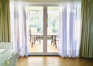 a dining room with sliding glass doors with a table at Azores Casa Hawaii in Nordeste