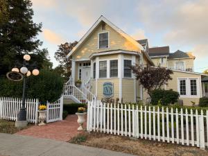 a white picket fence in front of a white house at The Inn at Benicia Bay in Benicia