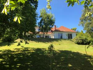 een huis bovenop een grasheuvel met bomen bij Suite alcôve confort in Freneuse