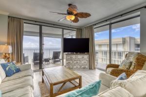 a living room with a flat screen tv and a couch at Bluewater Apartments in Orange Beach