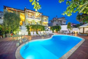 une villa avec une piscine en face d'une maison dans l'établissement Vera Lilli, à Thasos