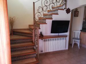 a living room with stairs with a flat screen tv at Casa Rural Los Pineros in Montán