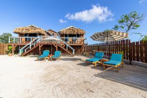 a group of chairs and umbrellas on a beach at Casa Nova Cabanas in San Pedro