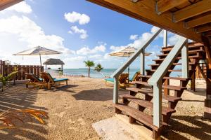 a beach with chairs and umbrellas and the ocean at Casa Nova Cabanas in San Pedro