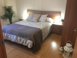 una camera con un grande letto con testiera in legno di Apartamentos Turísticos Clavero 1 a Plasencia