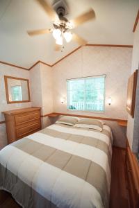 a bedroom with a bed and a ceiling fan at Bethpage Two-Bedroom Cottage 4 in Urbanna