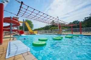 a large swimming pool with a water slide and slides at Bethpage Two-Bedroom Cottage 4 in Urbanna