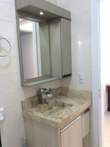 een badkamer met een wastafel en een spiegel bij Residencial Annabel APTO 02 in Bombinhas