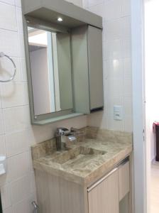 a bathroom with a sink and a mirror at Residencial Annabel APTO 02 in Bombinhas