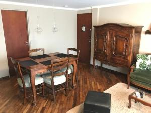 comedor con mesa de madera y sillas en Marín Apartments en Puerto Iguazú