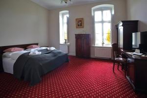 a bedroom with a bed and a red carpet at Pałac Spichrz in Borcz