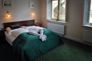 a bedroom with a bed with a green blanket at Pałac Spichrz in Borcz