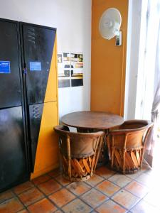 
a kitchen with a table and chairs and a refrigerator at Hostel Hospedarte Centro in Guadalajara
