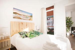 a bedroom with a white bed with towels on it at BEACH APARTMENT with BBQ, PS4, BIKES! in Castelldefels