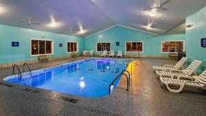 a large swimming pool with white chairs around it at SureStay Hotel by Best Western Greenville in Greenville