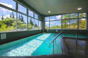 a large indoor swimming pool with windows in a house at Omuta Heights in Ōmuta
