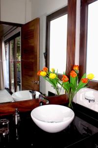 Un baño con un lavabo y un jarrón de flores. en NISE, en Puerto Vallarta 87 fotos más
