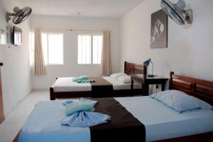 una camera da letto con due letti e una finestra di Hotel Joohn Gay only LGBTIQ a Melgar
