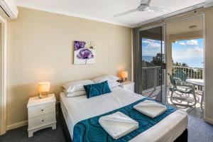 a bedroom with a large bed and a large window at On The Beach in Trinity Beach