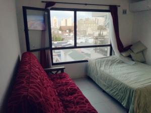 una camera da letto con un letto e una grande finestra di Edificio DOMUS a Necochea