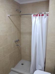un bagno con doccia con tenda da doccia bianca di Edificio DOMUS a Necochea