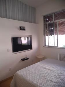 ein Schlafzimmer mit einem Bett und einem TV an der Wand in der Unterkunft Studio Copacabana in Rio de Janeiro