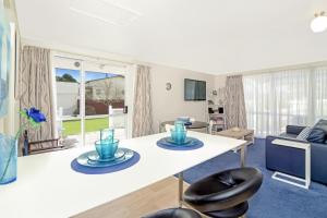 sala de estar con mesa blanca y sillas en Coromandel Apartments en Coromandel Town
