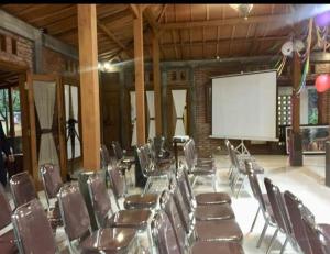 une salle de conférence avec des chaises et un écran blanc dans l'établissement Omah Joglo Semarang, à Semarang