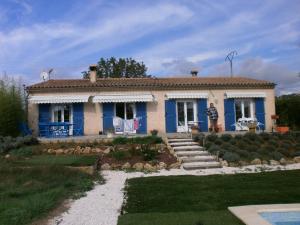 una casa azul y blanca con patio en Les Tourterelles, en Callian
