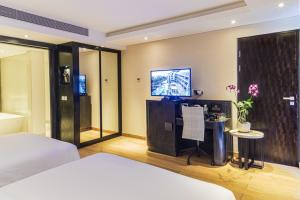 a bedroom with a bed and a tv on a wall at Double - Six, Luxury Hotel - Seminyak in Seminyak