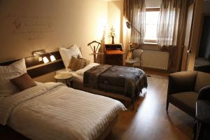 una habitación de hotel con 2 camas y una silla en Art-Hotel Sonnenhof, en Hanau am Main